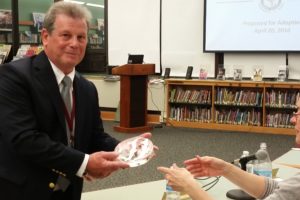 Eighth-grade science teacher Fred DePalma shows moon rocks to Harrison Central School District Board of Education trustee Lindy Wolverton at the April 20 board meeting. Photo/Sarah Varney
