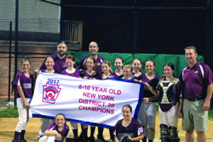 Harrison’s 10u girls softball team poses with the District 20 Little League banner on June 30 after beating Eastchester 10-4 to win the title. Contributed photo