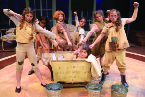 Meet the Orphans of “Annie”: from left, Ruby Griffin as July; Anika Bobra as Tessie; Peyton Ella as Annie;
Gabriella Uhl as Kate; Nora Kennedy as Pepper; and Maureen Henshaw as Duffy. In basket, Haylie Shea
Christiano as Molly.