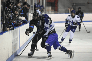 The Huguenot and Titans battle for a loose puck along the boards on Jan. 24.  Photos/Mike Smith